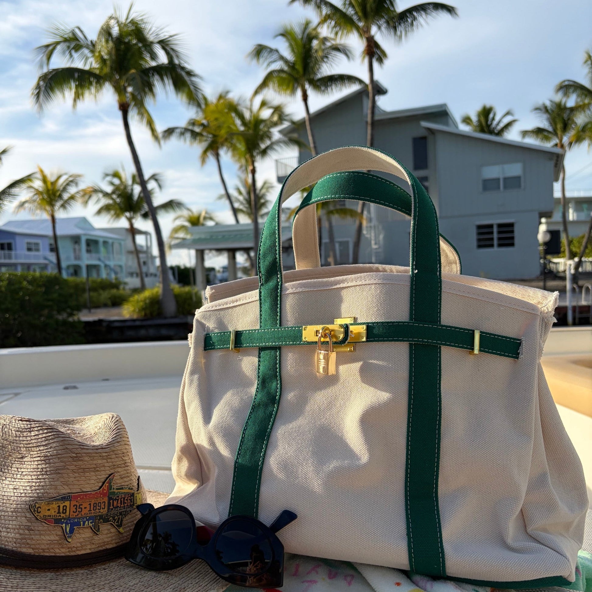 Green Boatkin bag on a boat deck with palm trees and houses in the background