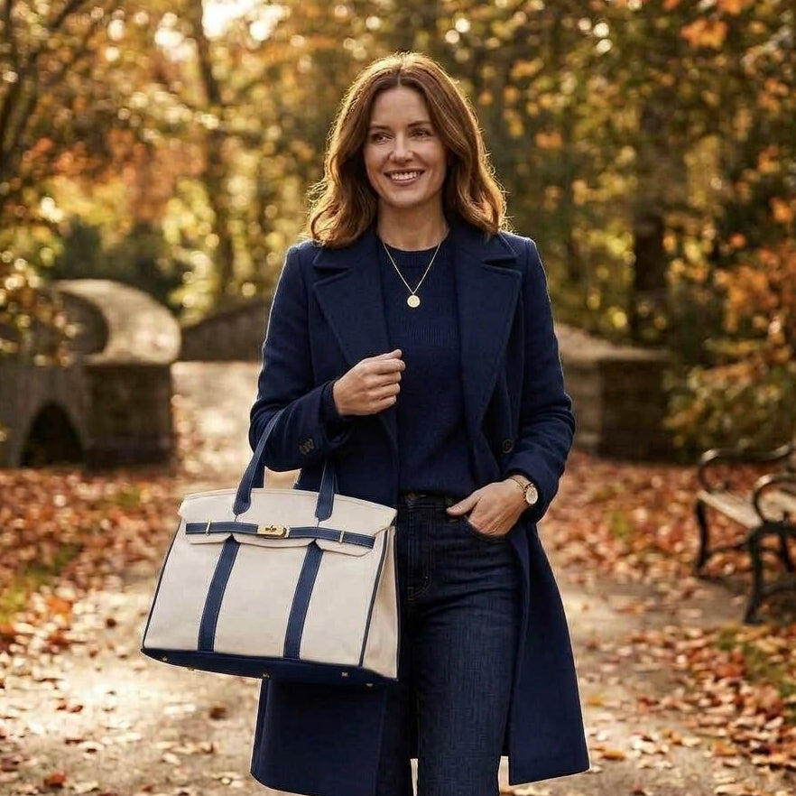 Woman carrying a blue trim Boatkin bag in a park in fall.