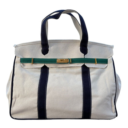 Front studio view of the cream canvas Boatkin tote bag featuring deep navy blue straps and forest green horizontal accents.