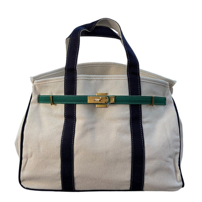 Straight front view of the cream canvas Boatkin tote bag featuring navy blue vertical straps and a forest green belt horizontal strap.
