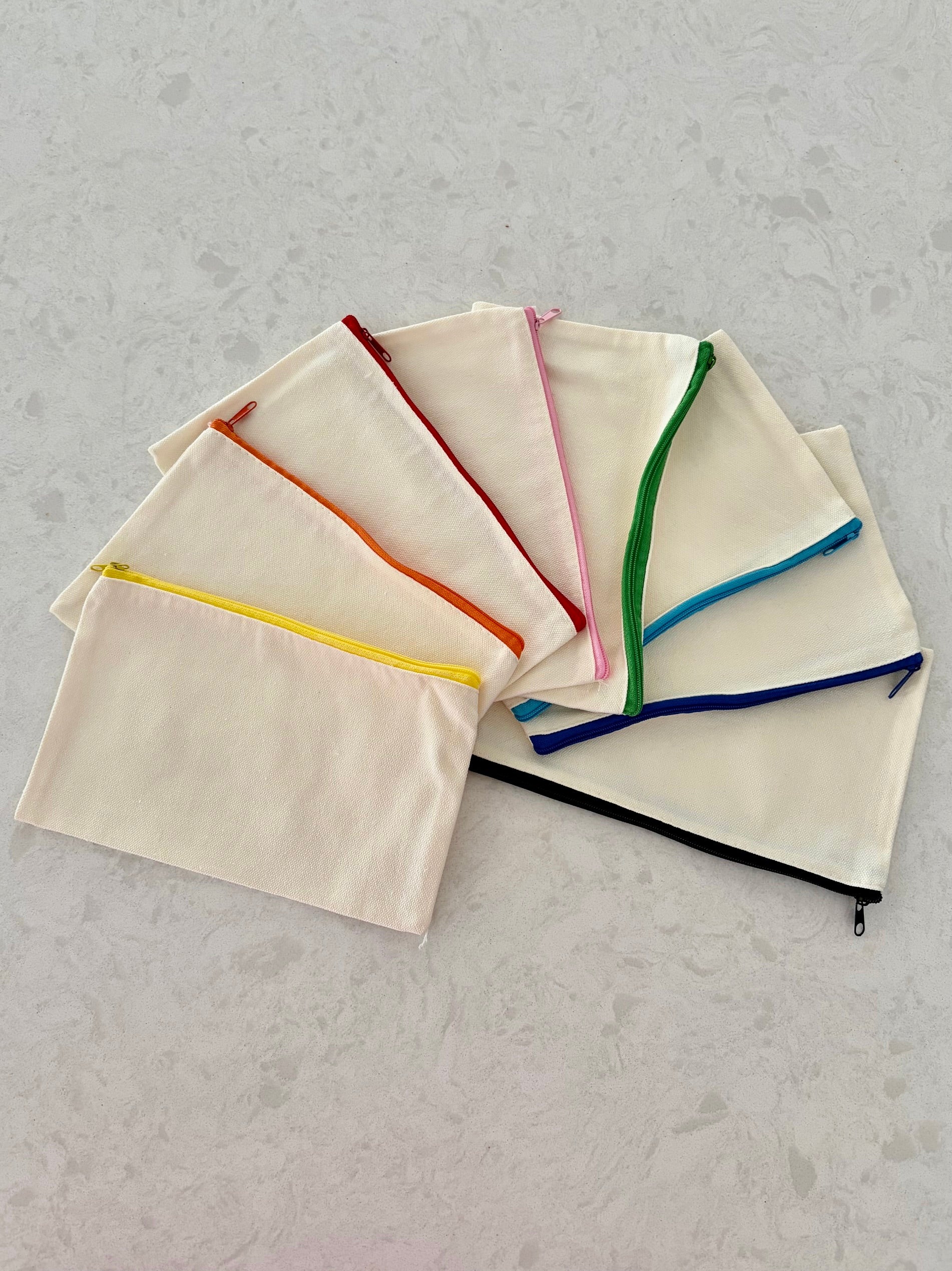 Set of Boatkin zip pouches with colorful zippers on a gray surface