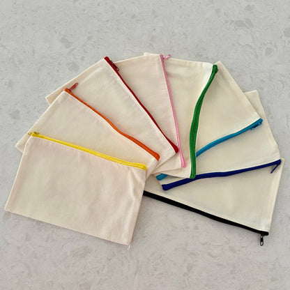 Set of Boatkin zip pouches with colorful zippers on a gray surface
