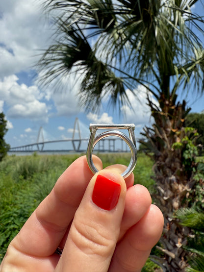 Display of woman's hand holding bold modern offset ring