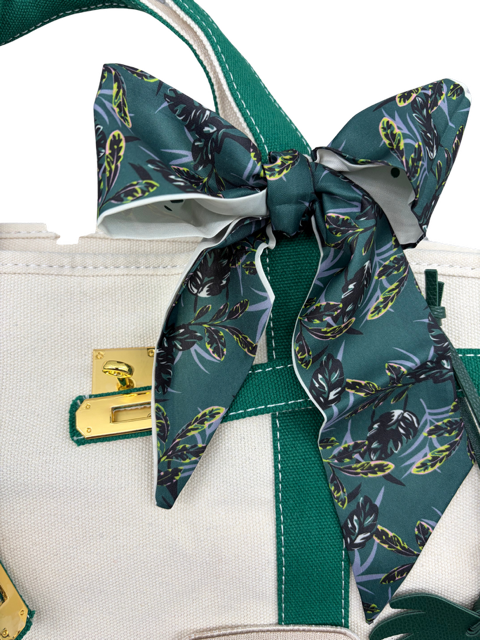 Green botanical leaf print twilly scarf tied in a bow on the handle of the Charleston canvas tote bag with gold hardware