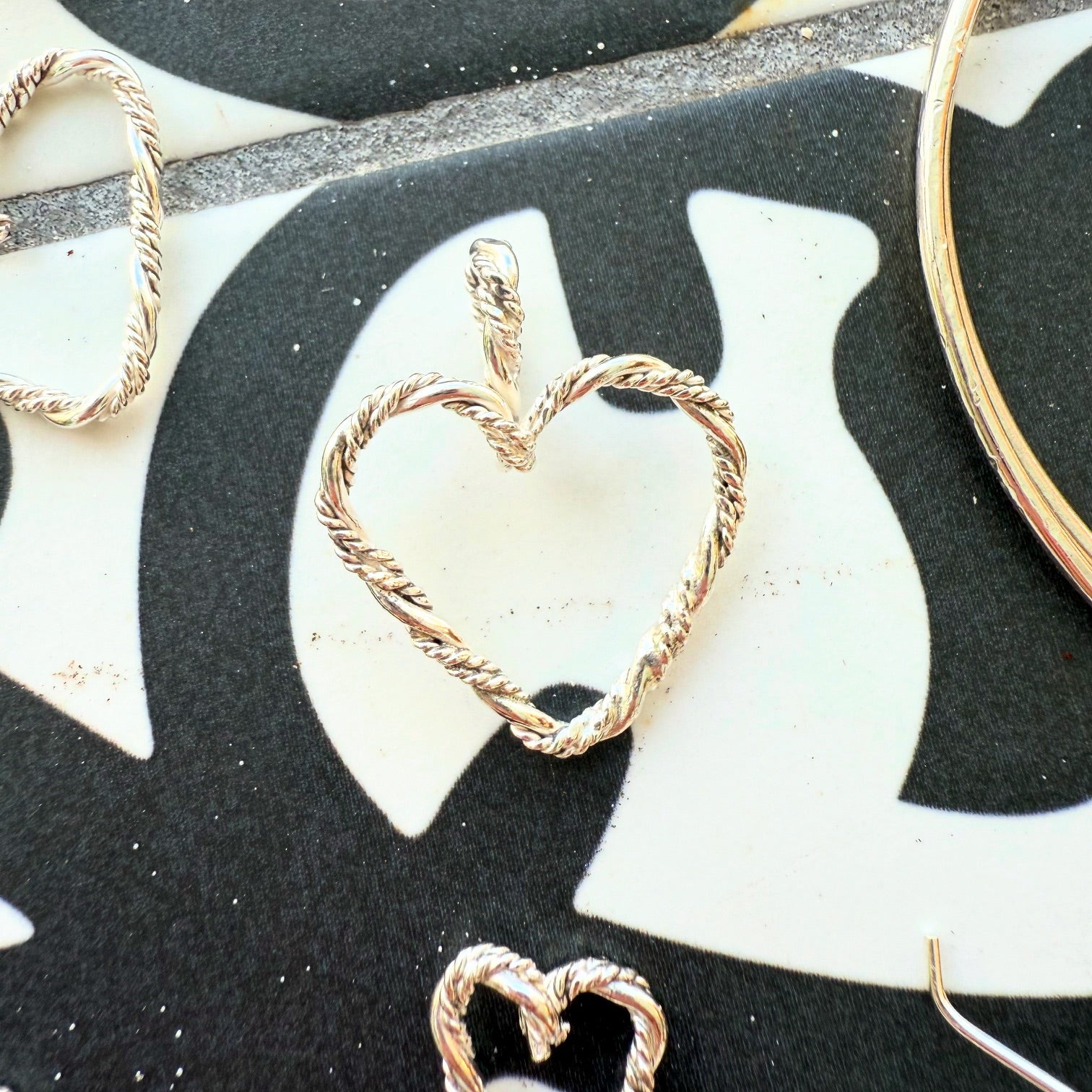 Close-up of a braided sterling silver heart pendant