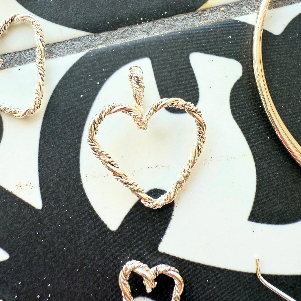 Close-up of a braided sterling silver heart pendant