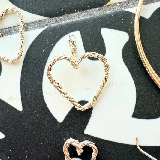 Close-up of a braided sterling silver heart pendant