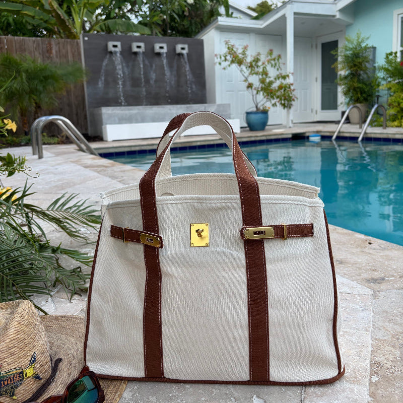Brown Boatkin bag open by a pool.