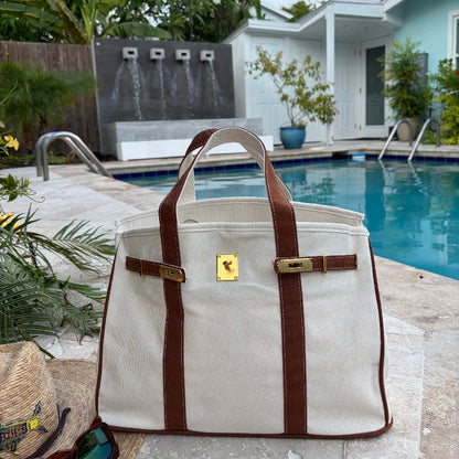 Brown Boatkin bag open by a pool.