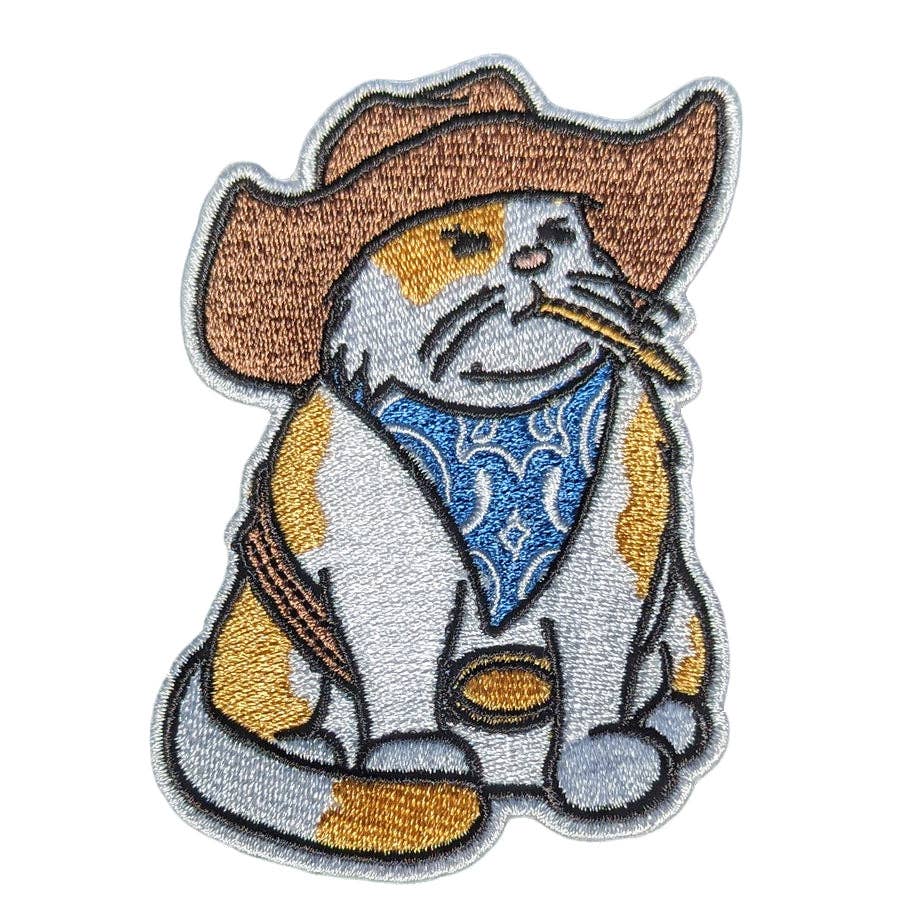 Embroidered patch of a cat in cowboy attire with a bandana and hat on a white background