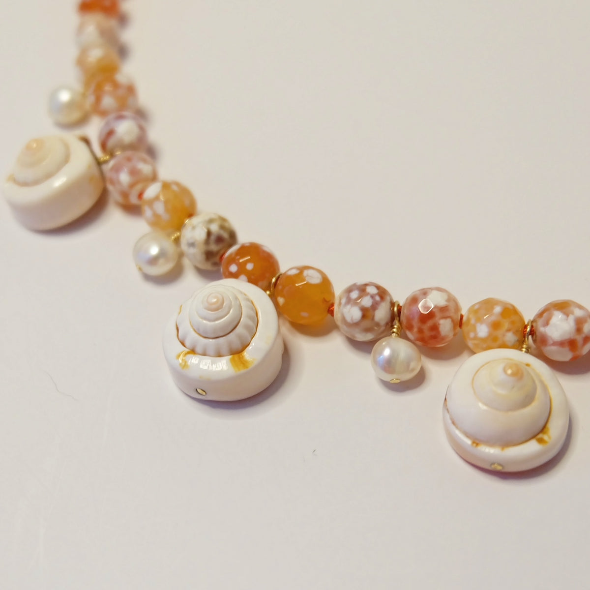 Pair of handmade cowrie shell and pearl earrings in 14K gold-filled