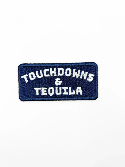 A rectangular embroidered patch with a dark navy blue background and white text reading 'TOUCHDOWNS & TEQUILA' on a plain white background.