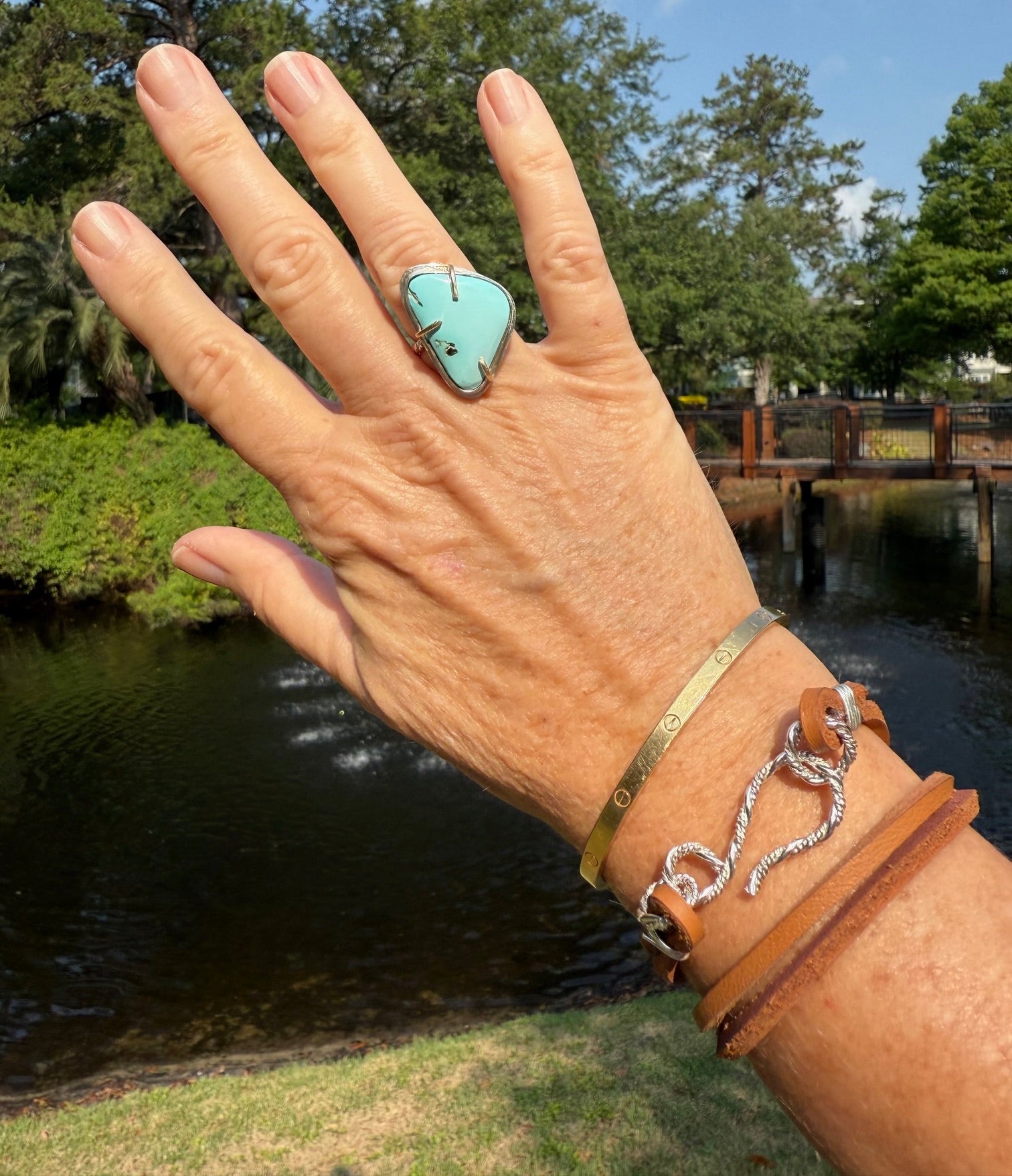 Woman wearing a brown double wrap leather bracelet with a sterling silver clasp