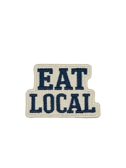 Eat Local embroidered iron-on patch with navy lettering on a cream background