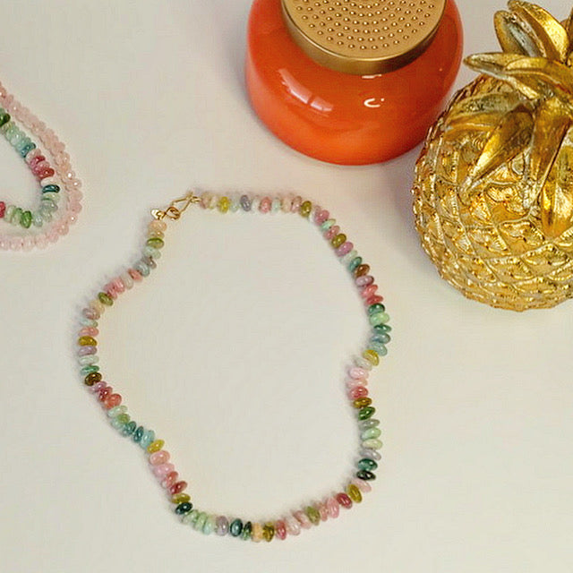 Flat lay of 14K gold watermelon tourmaline candy necklace displayed on a white background.