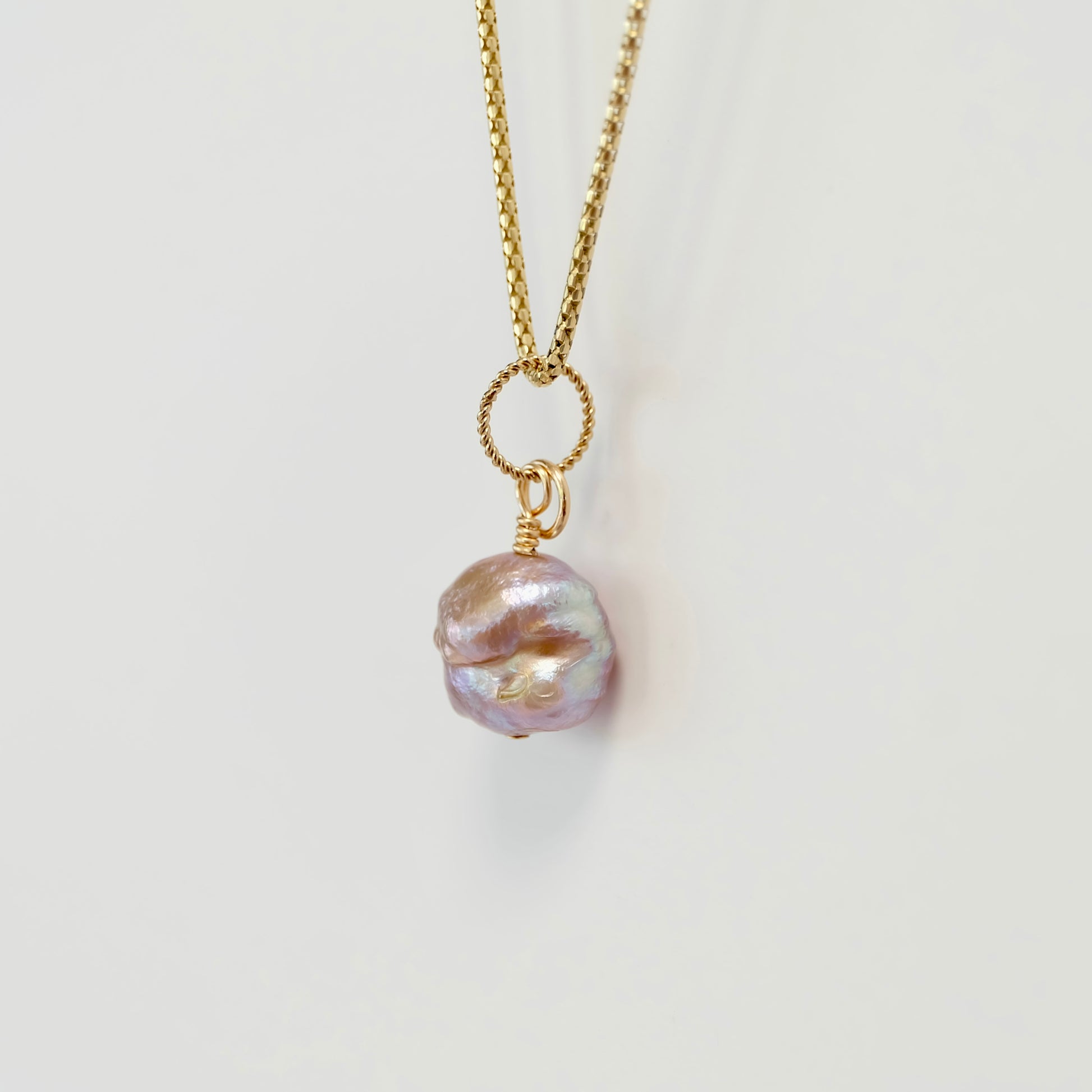 Handcrafted freshwater pearl charm on 14k gold-filled wire, showcasing elegance and natural beauty in a delicate design.
