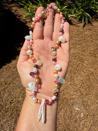 Side view of a hand-knotted pearl and gemstone necklace on a model