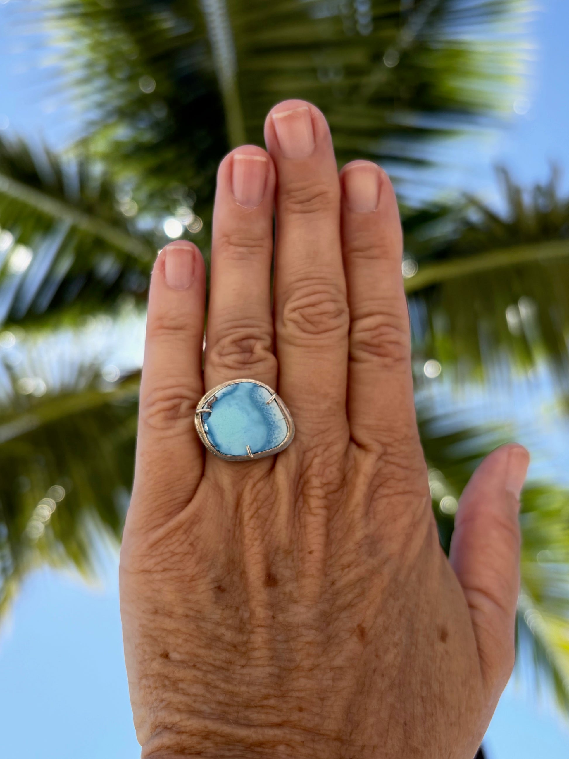 Woman's hand wearing a gold hills lavender turquoise ring
