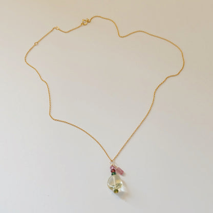 Close-up of green amethyst and tourmaline charms on a dainty gold-filled necklace