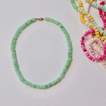 Green opal candy necklace hand-knotted on silk next to stacked colorful strands.
