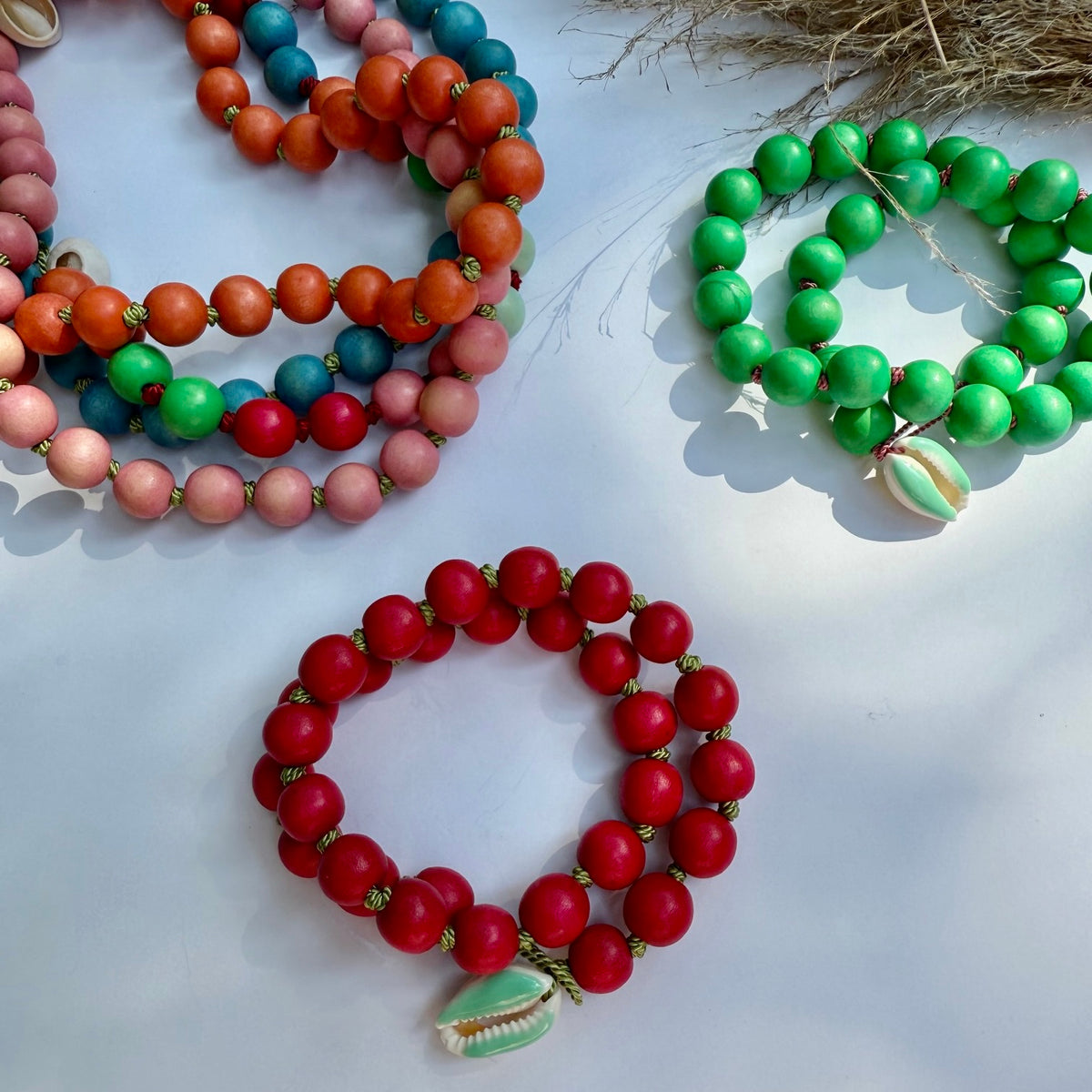 Colorful wood bead necklaces wrapped as bracelets on a white surface