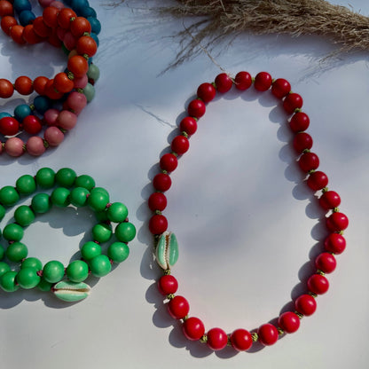 Red and green wood bead necklaces worn as wrap bracelets