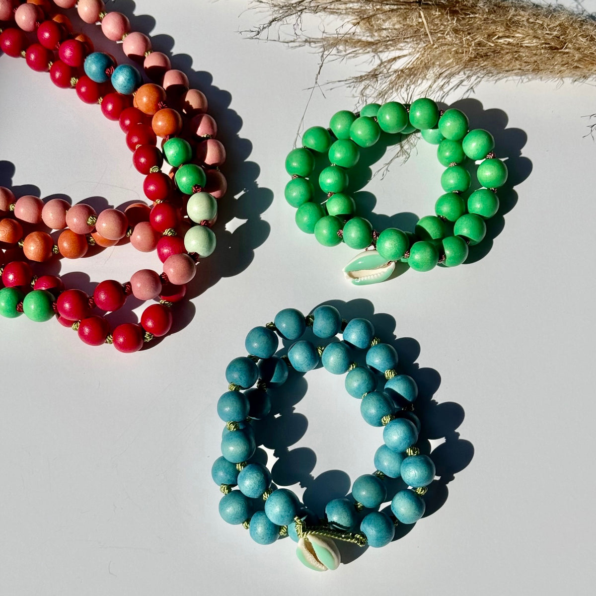 Three colorful wood bead necklaces wrapped twice as bracelets