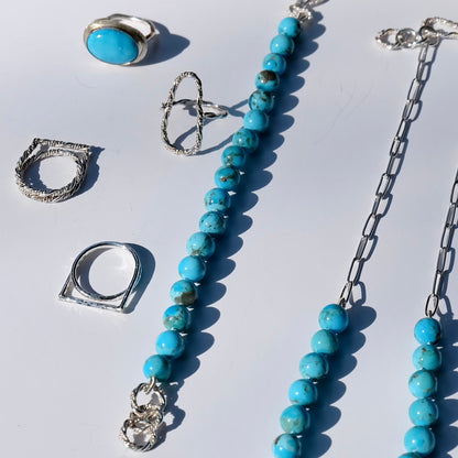 Kingman turquoise beaded bracelet styled with silver rings