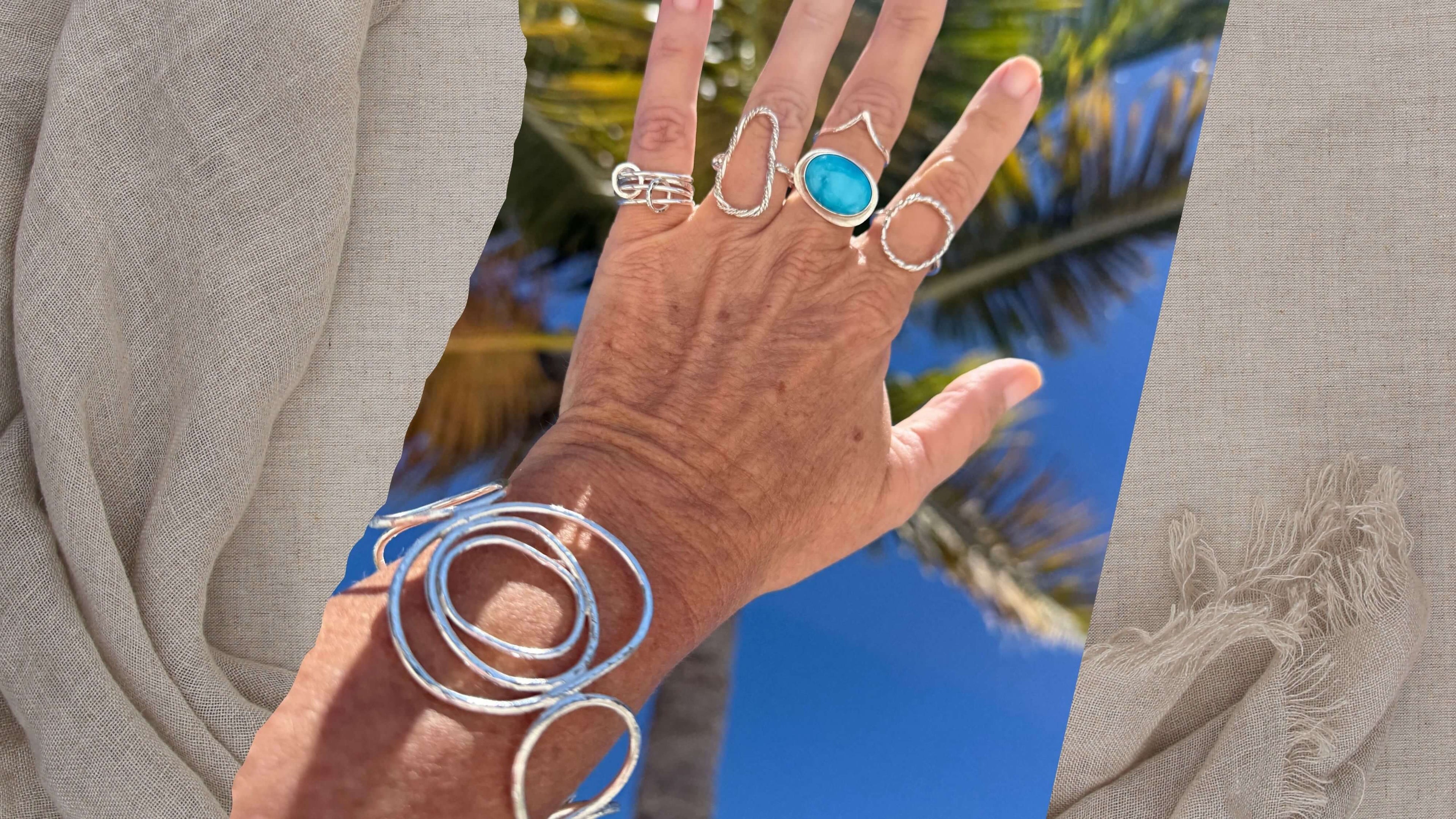 Woman's hand wearing a collection of handmade jewelry new arrivals