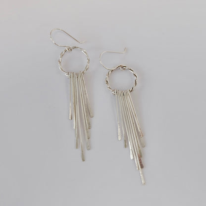 Elegant silver fringe earrings featuring delicate strands that sway gracefully, adding a touch of sophistication to any outfit.
