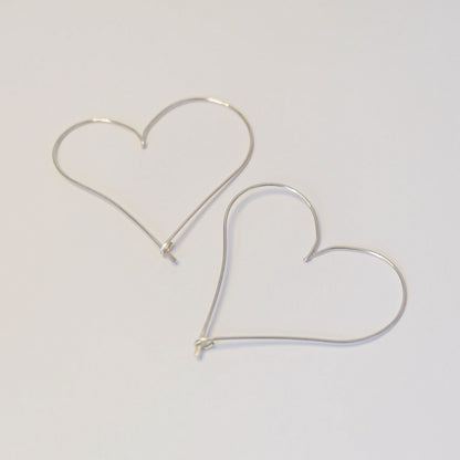  Elegant silver heart earrings, showcasing a delicate design that adds a touch of romance to any outfit.