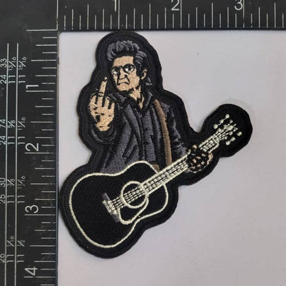 Embroidered patch of a Johnny Cash with a guitar, next to a ruler for scale.