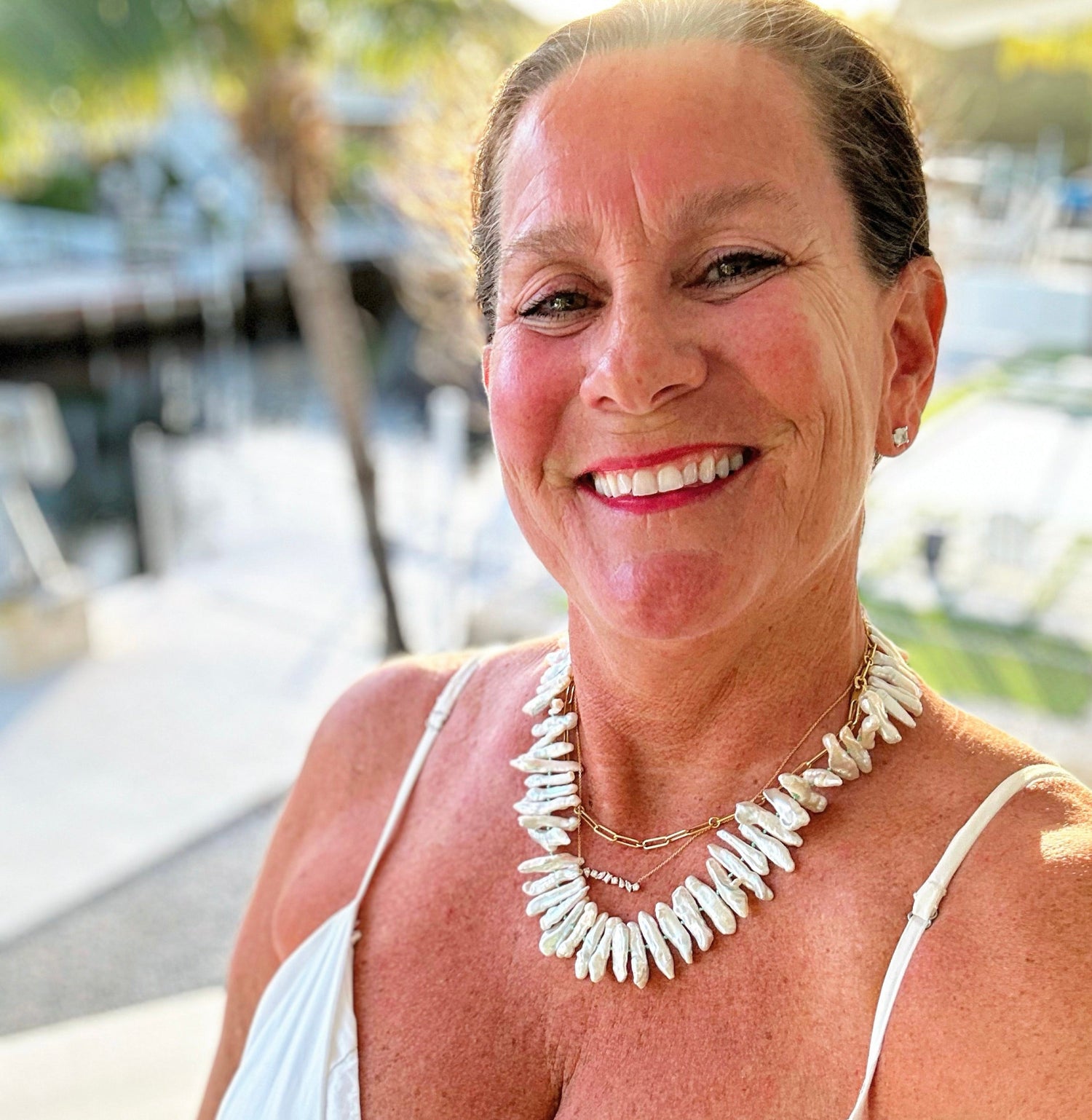 Karen, founder of Coral Strands in Key West, wearing a hand-knotted gemstone candy necklace.