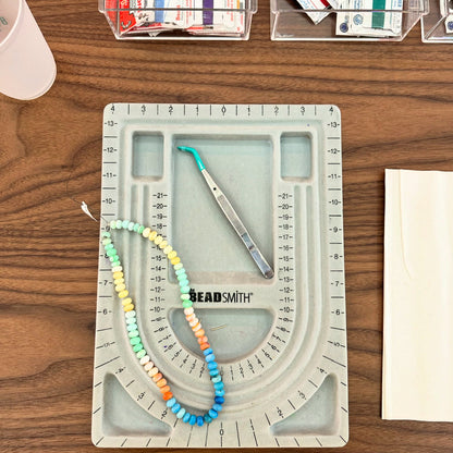 A colorful gemstone candy necklace laid out on a design board during a Key West jewelry class.