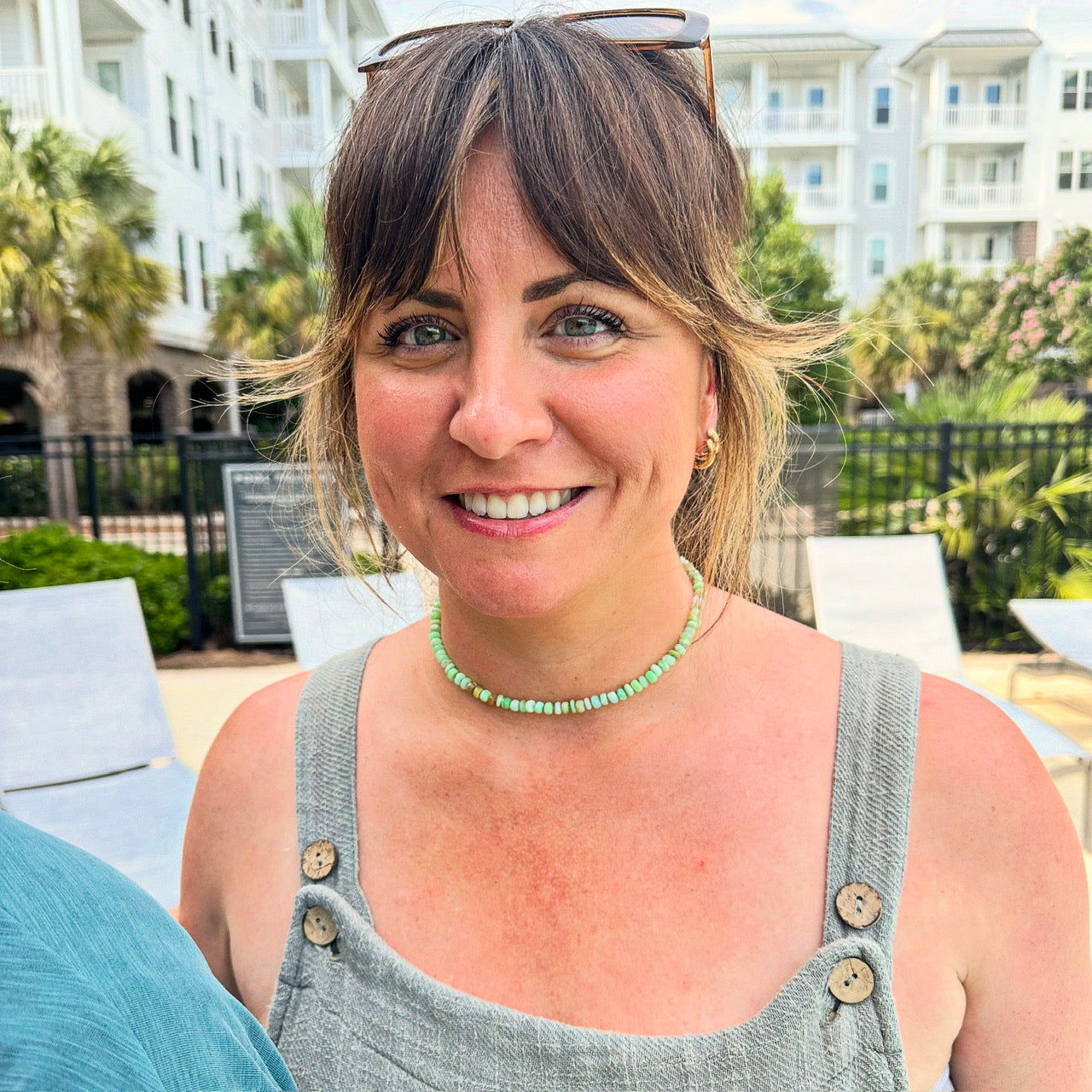 A student wearing a finished custom green opal candy necklace made in a Key West jewelry class.