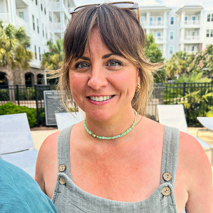 A student wearing a finished custom green opal candy necklace made in a Key West jewelry class.