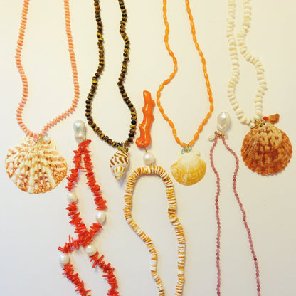 Crafting a custom gemstone and seashell necklace in a Key West workshop.