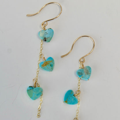 Display of Kingman turquoise heart dangle earrings in gold