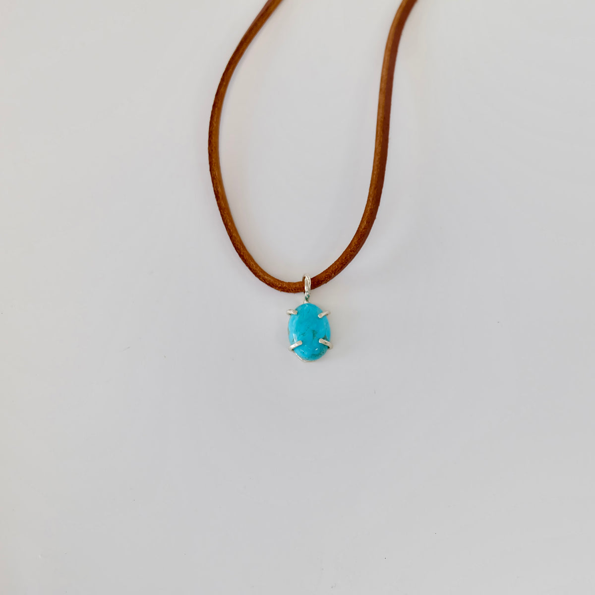 Close-up of a Kingman turquoise cabochon charm in sterling silver