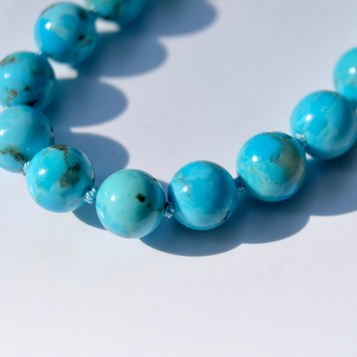 Hand-coiled French wire protecting the aqua silk on a turquoise paperclip necklace