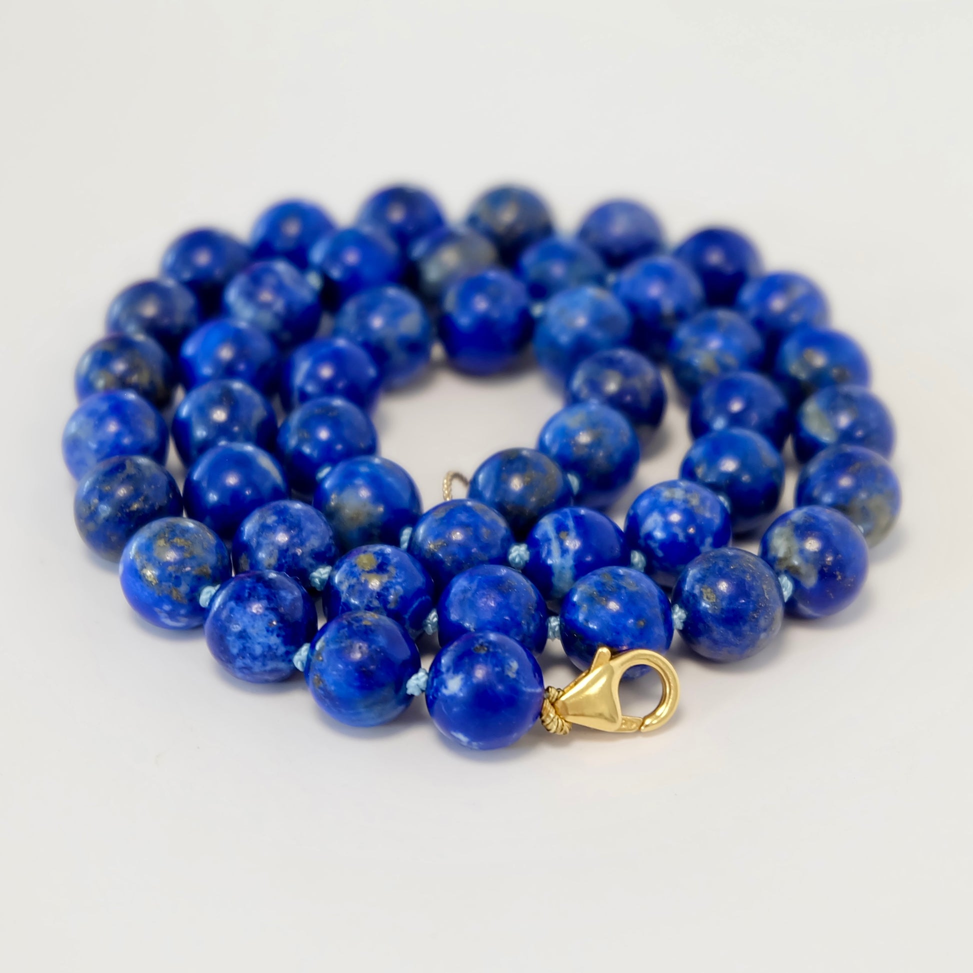 A beautiful knotted necklace featuring vibrant lapis beads, showcasing rich blue hues and a unique design.