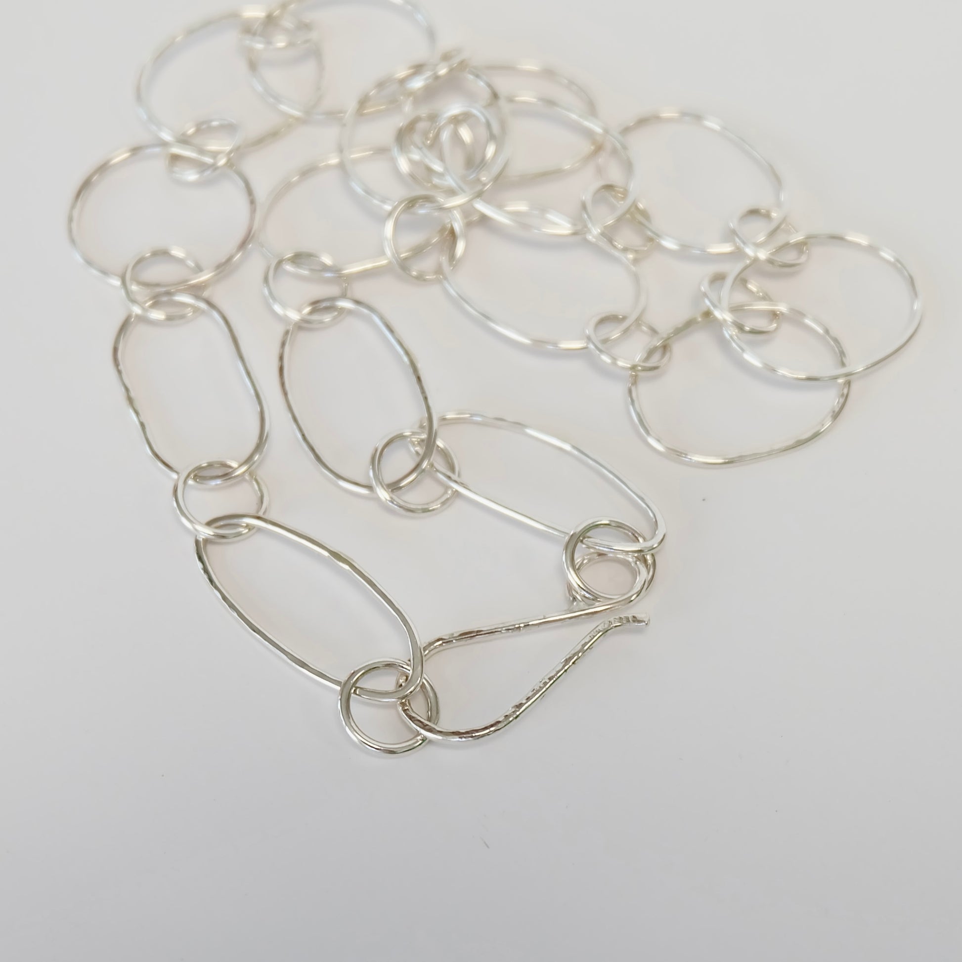 A refined silver link necklace, characterized by its seamless interlinking design, suitable for various occasions.
