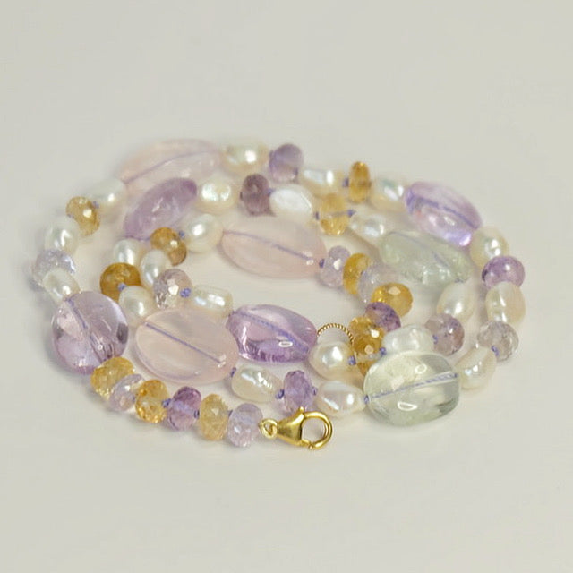Mixed gemstone beaded candy necklace on lavender silk, displayed