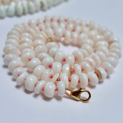 Close-up of mother of pearl beads hand-knotted on pink silk