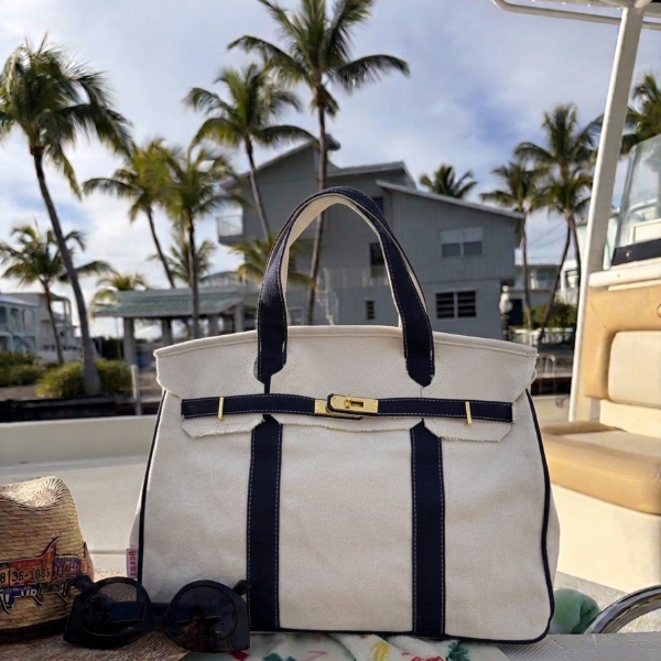 Navy blue Boatkin bag with on a boat with palm trees and a house in the background