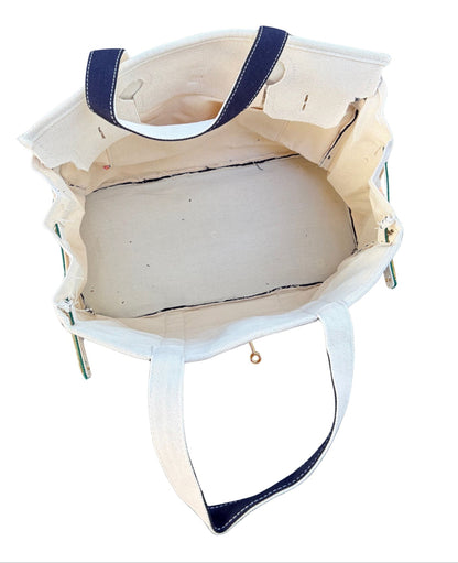 Navy and green Boatkin bag interior with a pocket on a white background. 