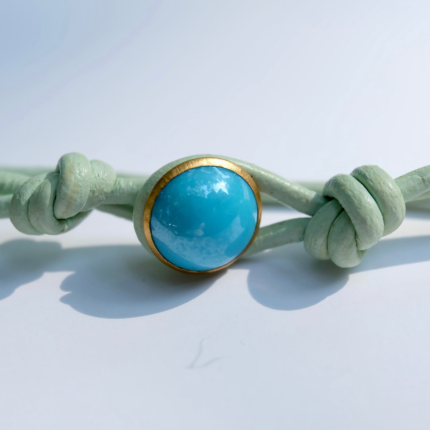 Necklace with a button and gold accent on a light gray background