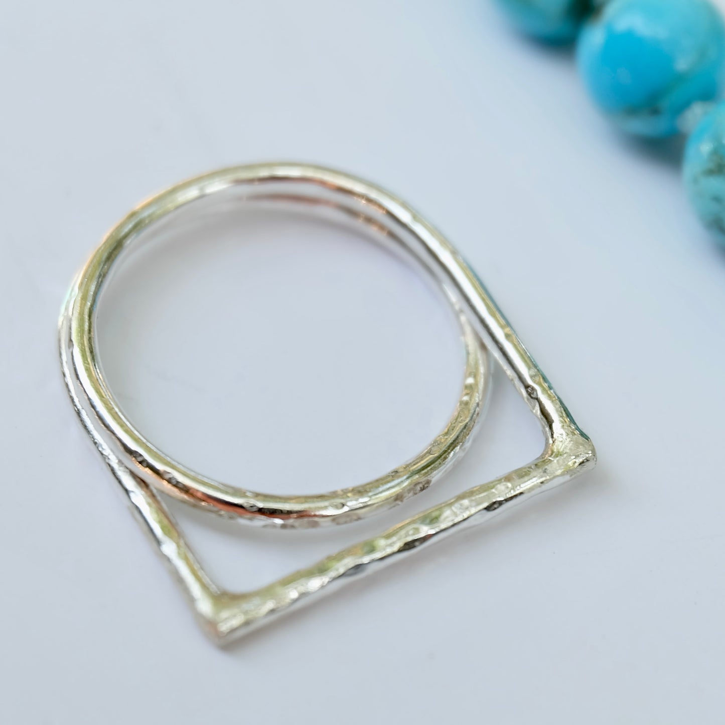 Offset ring with a geometric design on a light gray background