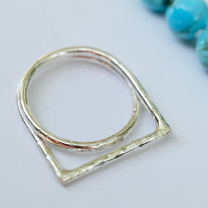 Offset ring with a geometric design on a light gray background