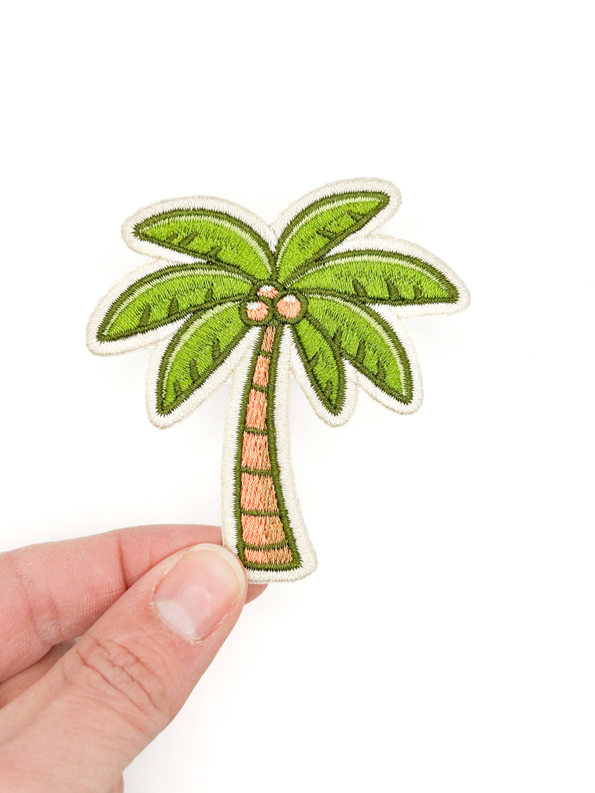 Embroidered iron-on patch of a green palm tree with a brown trunk